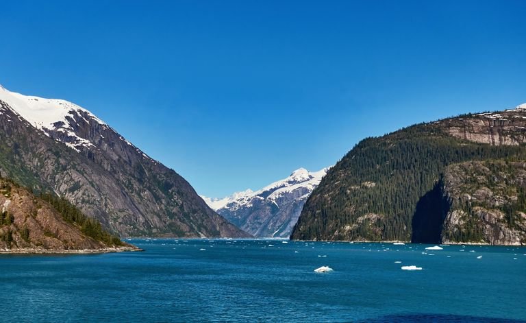 Breathtaking view of a fjord in Alaska with snowcapped mountains and crystal blue water.