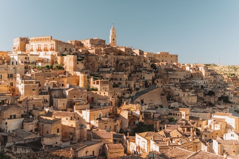 Explore the ancient stone dwellings of Matera, Italy, a UNESCO World Heritage site bathed in golden light.